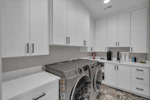 Laundry area with independent washer and dryer and cabinet space