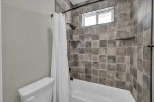 Full bath with shower / tub combo with curtain and toilet