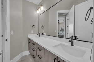 Ensuite bathroom featuring double vanity and tile patterned floors