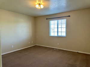 Primary room with carpet floors and a large window sending in natural light