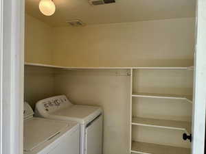 Laundry room featuring separate washer and dryer and convenient shelves