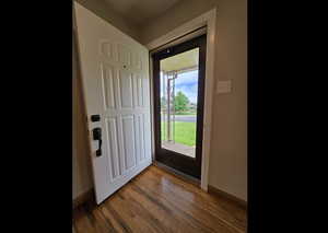 Foyer entrance with wood finished floors and baseboards