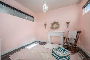 Sitting room with wood finished floors and a chandelier