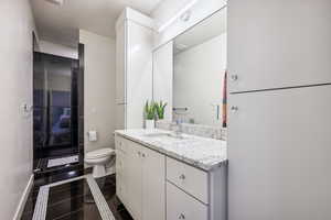 Bathroom with vanity, a shower stall, and tile patterned floors