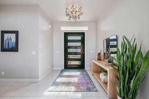 Entryway with a chandelier and light tile patterned floors