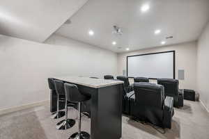 Home theater with light carpet and recessed lighting