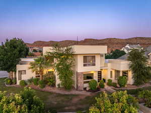 View of front of home featuring stucco siding, a mountain view, and stairway