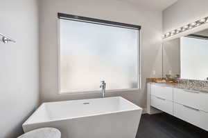 Full bath with vanity and a freestanding tub