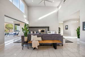 Living area with a towering ceiling, light marble finish floors, and recessed lighting