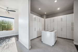 Spacious closet with a ceiling fan and carpet flooring