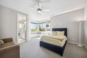 Bedroom with light colored carpet, connected bathroom, and ceiling fan