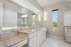 Bathroom with healthy amount of natural light, vanity, and tile patterned floors