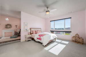 Carpeted bedroom featuring a ceiling fan and a chandelier