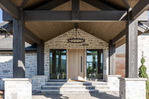 Entrance to property featuring stone siding