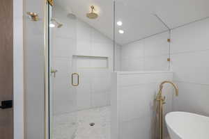 Bathroom with vaulted ceiling, a stall shower, a freestanding bath, and recessed lighting
