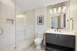 Full bathroom with a stall shower, vanity, lofted ceiling, and tile patterned floors