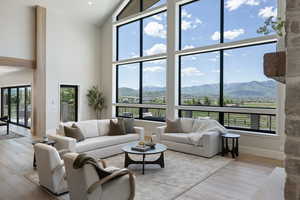 Living room with a mountain view, high vaulted ceiling, and hardwood / wood-style flooring