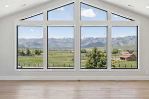 Unfurnished room featuring recessed lighting, a mountain view, wood finished floors, and a rural view