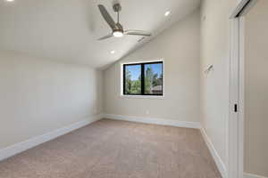 Empty room featuring light colored carpet, vaulted ceiling, recessed lighting, and ceiling fan