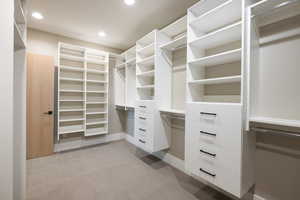 Walk in closet featuring light colored carpet