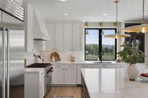 Kitchen featuring high end appliances, white cabinetry, and recessed lighting