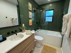 Full bath featuring tile patterned floors, vanity, bathing tub / shower combination, and tile walls