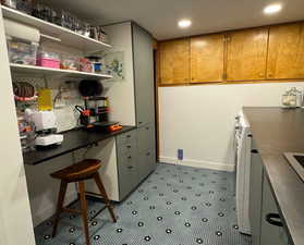 Kitchen with recessed lighting, open shelves, a desk, and dark countertops