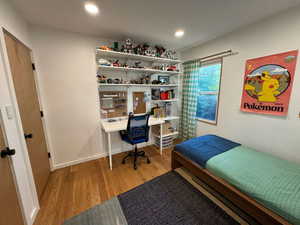 Bedroom featuring wood finished floors, an office area, and recessed lighting