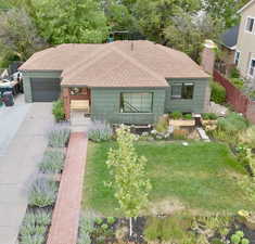 Ranch-style home featuring a shingled roof, concrete driveway, an attached garage, and a chimney