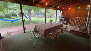 View of patio featuring a trampoline, outdoor dining area, and a grill