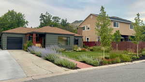 View of front facade featuring a garage and concrete driveway