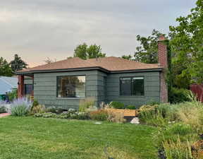 View of home's exterior with a chimney and a yard