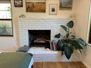 Detailed view of wood finished floors and a brick fireplace