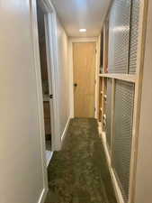 Corridor featuring carpet flooring and baseboards