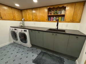Washroom featuring cabinet space, washer and clothes dryer, and recessed lighting