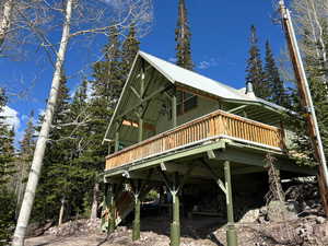 View of side of property featuring a wooden deck and a metal roof