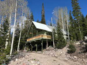 Rear view of property featuring a wooden deck and a metal roof
