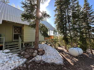 View of home's exterior with a metal roof, stairway, and a wooden deck