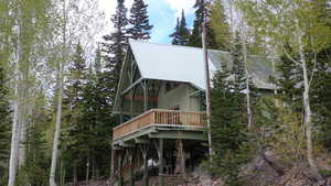 Rear view of property featuring a deck and a metal roof