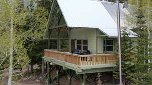 Back of property with a metal roof and a wooden deck