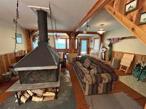 Rec room featuring a wainscoted wall, wooden walls, and a wood stove
