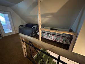 Carpeted bedroom featuring vaulted ceiling