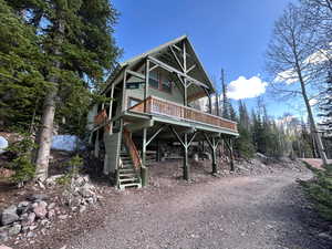 View of front of house featuring stairs and a deck
