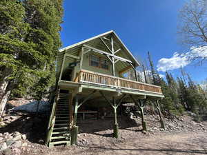 View of front of home featuring stairs and a deck