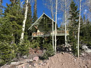 View of side of home featuring a wooden deck