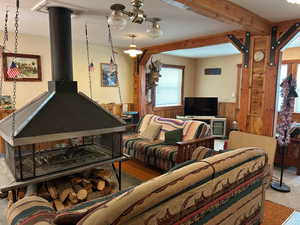 Carpeted living area featuring a wainscoted wall and wood walls