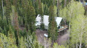 Aerial view of property and surrounding area with a forest