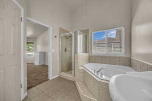Bathroom featuring a whirlpool tub, a shower stall, and tile patterned floors