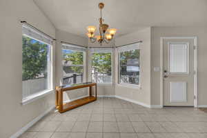 Unfurnished sunroom featuring a chandelier