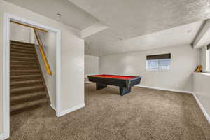 Game room with carpet flooring, a textured ceiling, and billiards